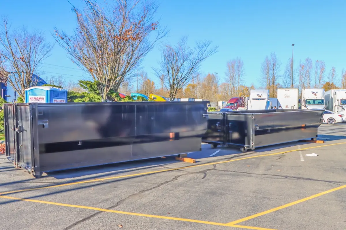Professional dumpster rental service with roll-off container on residential driveway in Handy